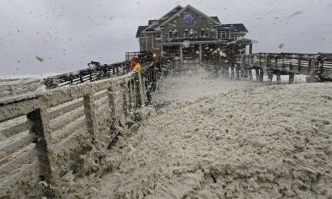 High winds blow sea foam onto Jeanette&amp;#039;s Pier in Nags Head, N.C., on Sunday, as wind and rain from Hurricane Sandy move into the area. Governors from North Carolina to Connecticut have declar