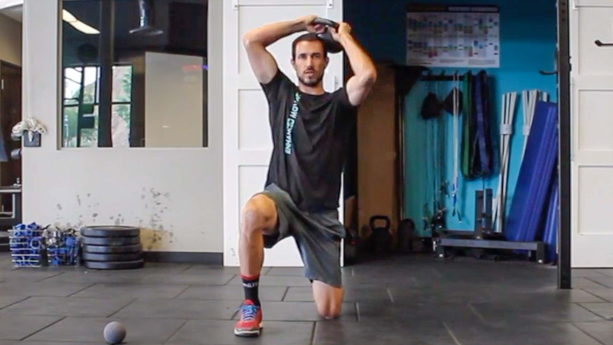 Man doing kettlebell halo in semi-kneeling at gym