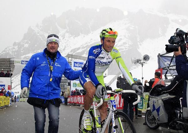 Ivan Basso (Liquigas-Cannondale) is assisted after finishing atop the Passo Pordoi.
