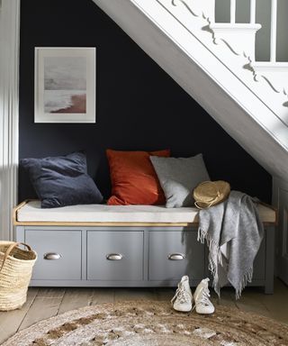 An under stairs idea with a boot bench with drawers and blue painted alcove