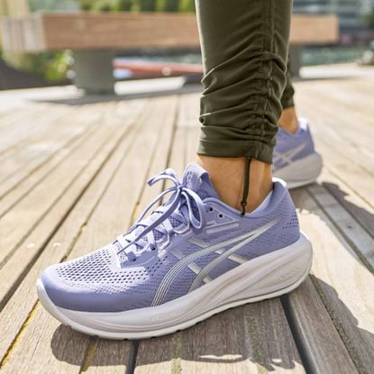 Woman wearing ASICS Cumulus sneakers in purple