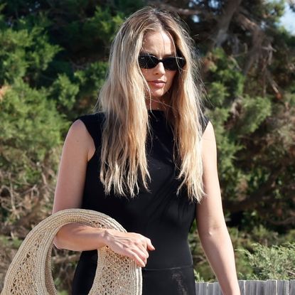 Margot Robbie wore a Jacquemus raffia basket bag and Ala&iuml;a mesh ballet flats in Ibiza