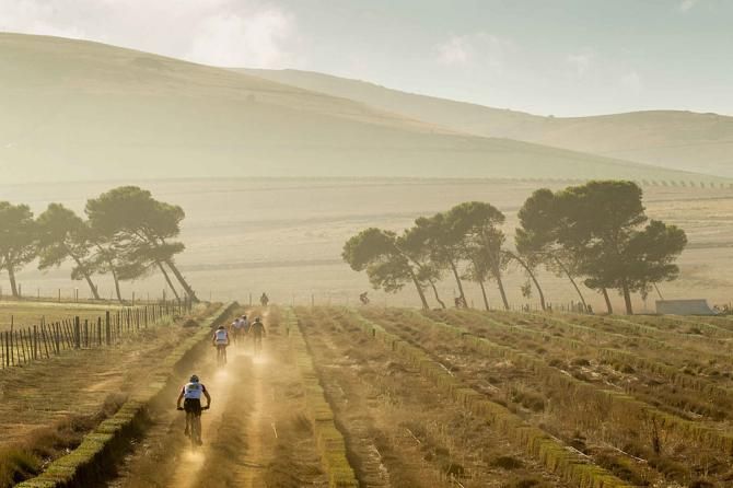 Riders pass through a farm during the prologue