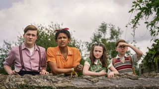 Julian (Elliott Rose), George (Diaana Babnicova), Anne (Flora Jacoby Richardson), and Dick (Kit Rakusen) leaning on a wall