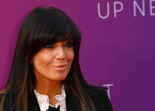 Claudia Winkleman attends Sky's Up Next event wearing her dark hair down, a black jacket posting against a purple background