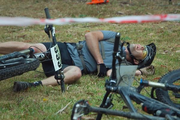 Steven Woolcock of Victoria is happy to fall off his bike exhausted at the end of the final race in Strahan yesterday.