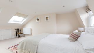 Cream bedroom with bed in mansard loft extension