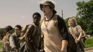 David Jonsson and Cooper Hoffman watch something horrific along with their fellow walkers in The Long Walk. 