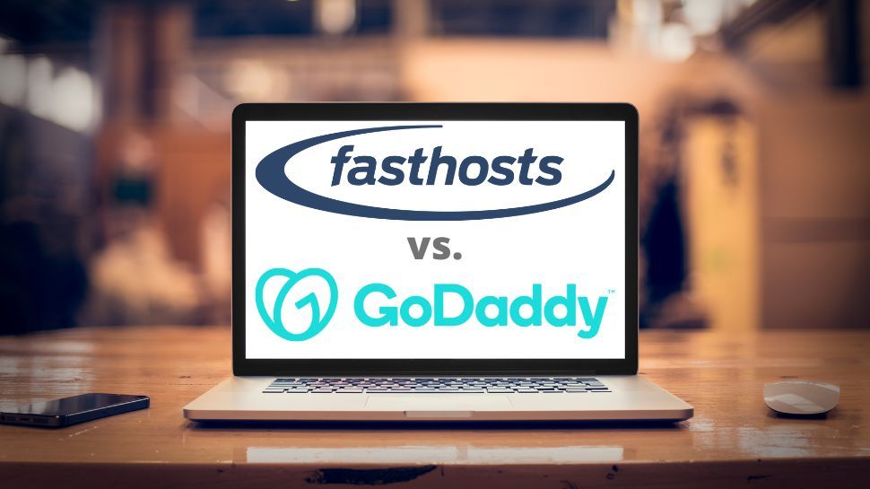 Fasthosts vs GoDaddy logo on laptop screen on a table