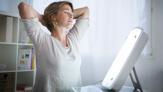 Woman sitting in front of a SAD lamp