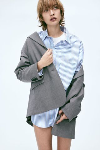 model wears Oversized Poplin Shirt with gray blazer over it