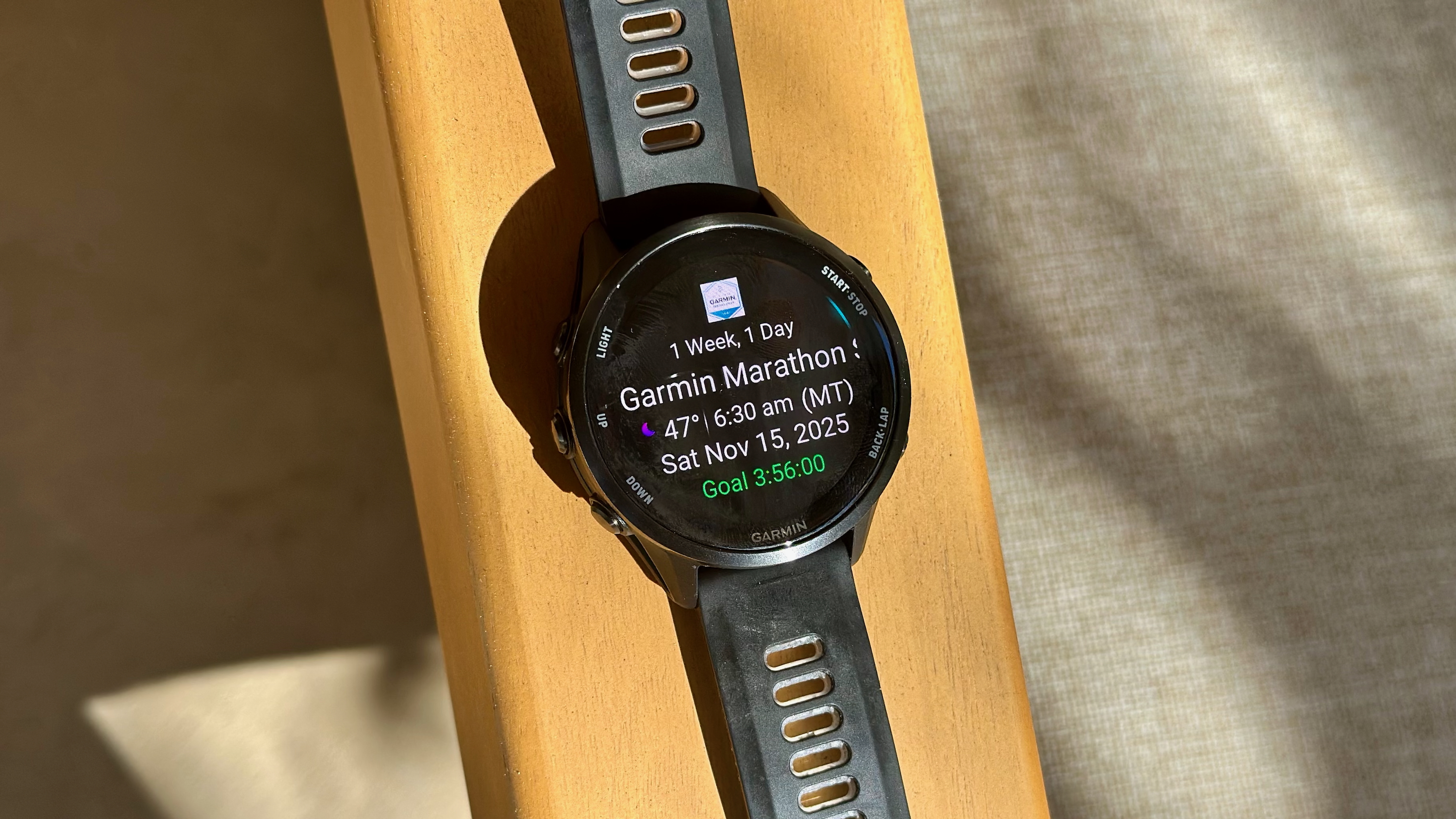 The Garmin Forerunner 970 sitting on an armrest showing stats about my upcoming race, the Garmin Tucson Marathon.