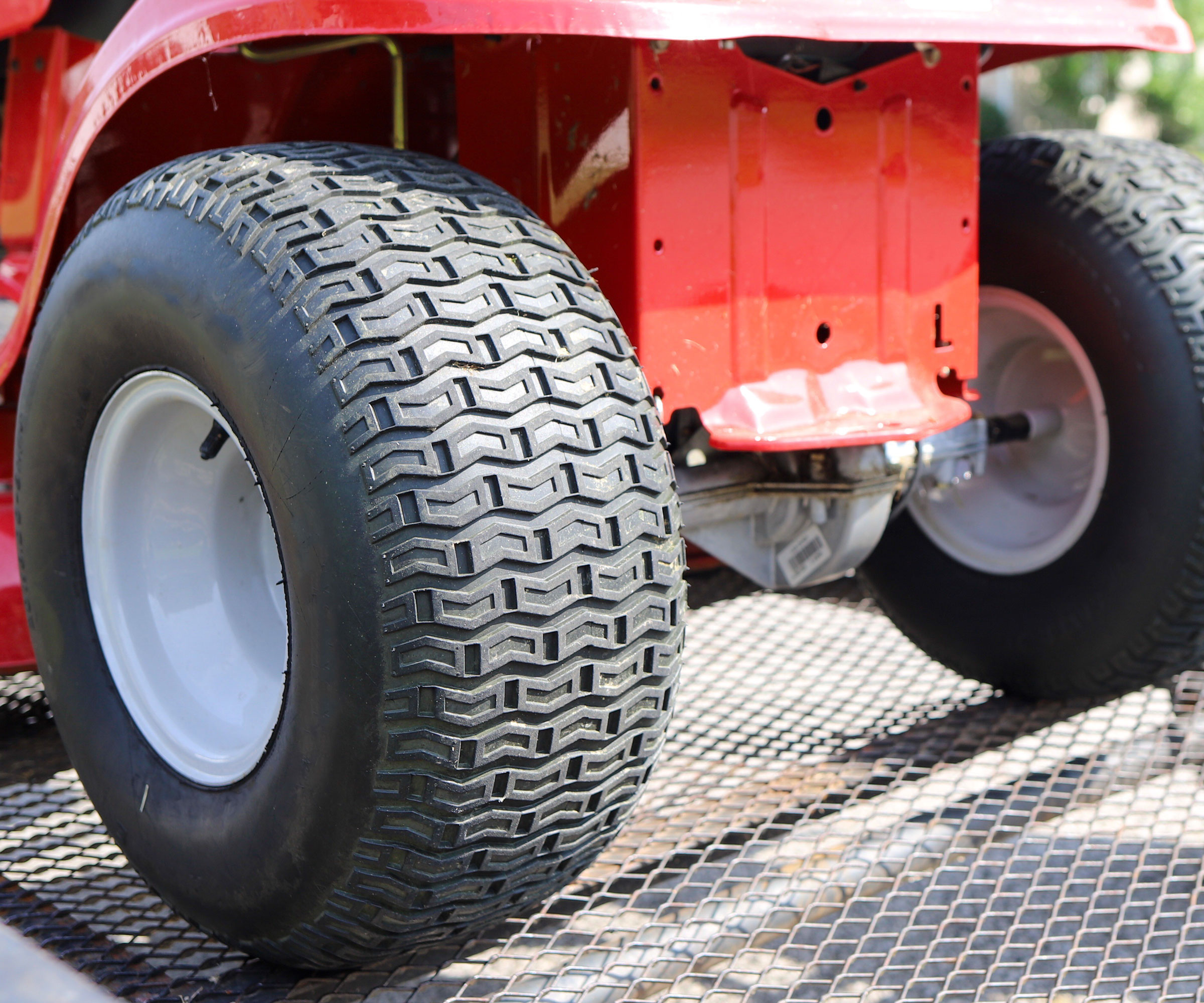detail of red riding lawn mower tires showing well maintained tread