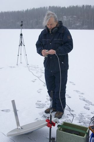 Physicist Unto K. Laine setting up his aurora recording equipment on a frozen lake in southern Finland.