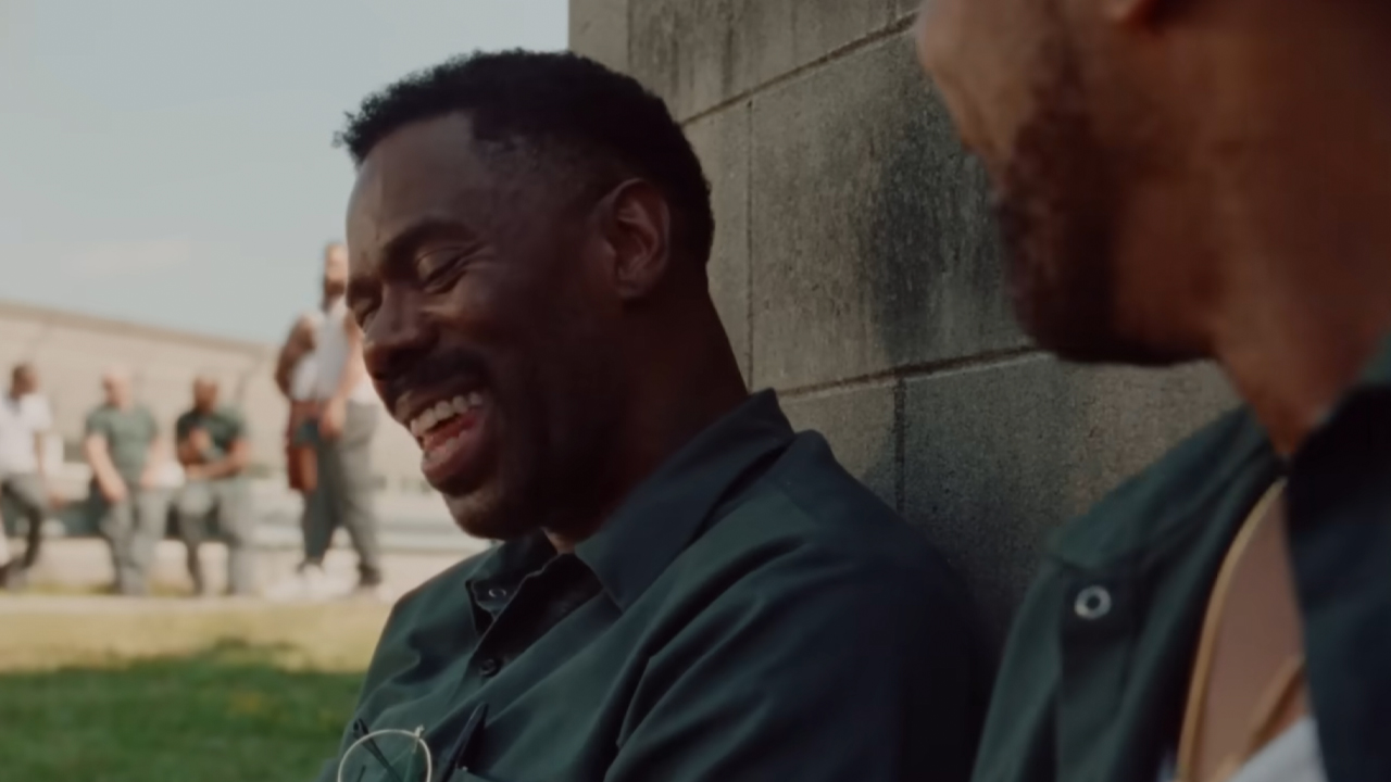 Colman Domingo laughs while inmates walk the yard behind him in 2024's A24 hit dram Sing Sing.