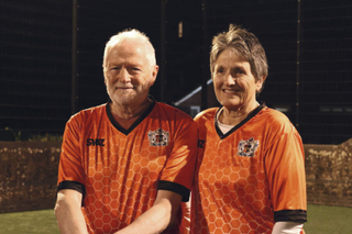 man and woman together wearing football shirts