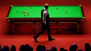 Snooker player rounds the table at the Snooker World Championship at the Crucible in Sheffield