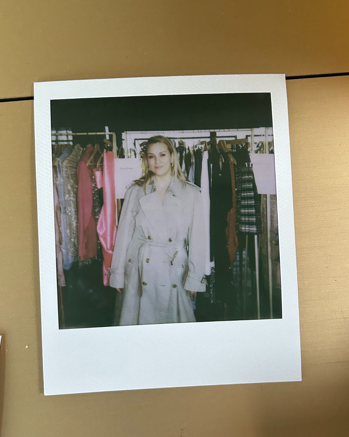a polaroid of clementina jackson wearing a burberry trench coat