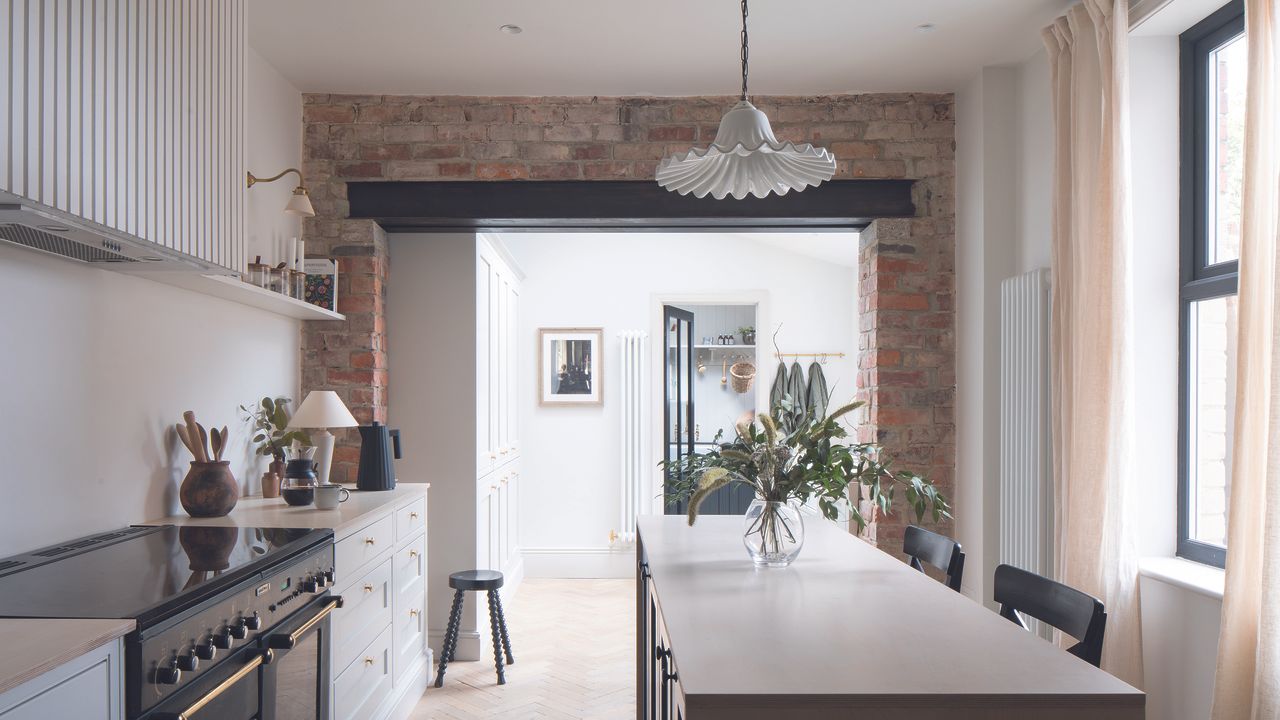 White kitchen with island and curtains on back window