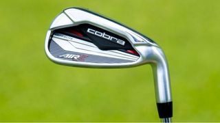 The fast swinging Cobra Air-X Irons and their black and red cavity-backed clubhead pictured on a green background on the golf course