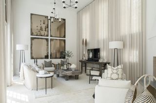 white living room with tv, white drapes, rustic feel, antiqued mirrors, white floor lights, wooden console and coffee table, armchairs, one couch