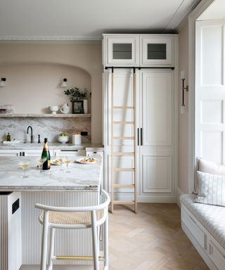 A white kitchen with an island and shelving