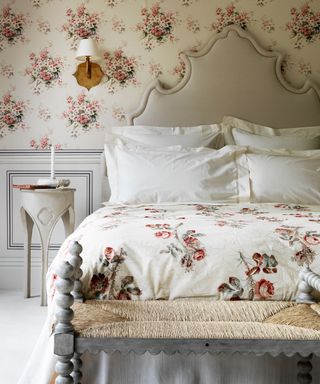 An example of headboard ideas with floral wallpaper that matches the bedding on a grand bed