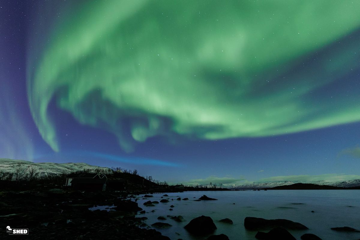 blue ribbon of light appearing over Abisko National Park, Sweden.