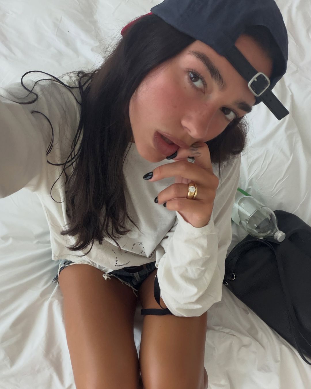Dua Lipa wearing black nail polish in the summer.