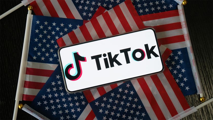 Smartphone displaying TikTok logo on a bed of American flags