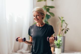 Woman doing rotator cuff exercise with light dumbbells