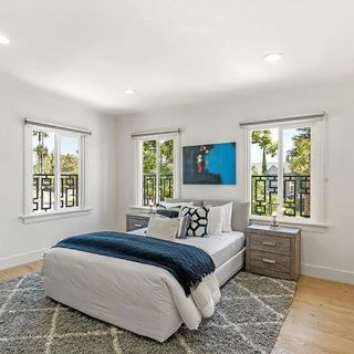 Bedroom with white walls and wooden flooring