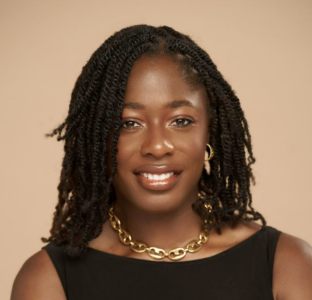 a black woman with dark twists wearing a gold necklace and black top smiling at the camera