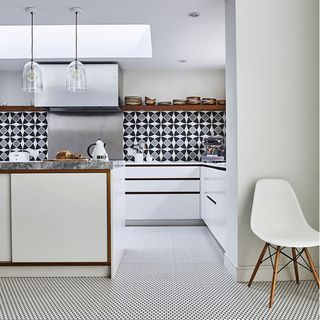 black and white kitchen with retro wall and floor tiles and hanging lights
