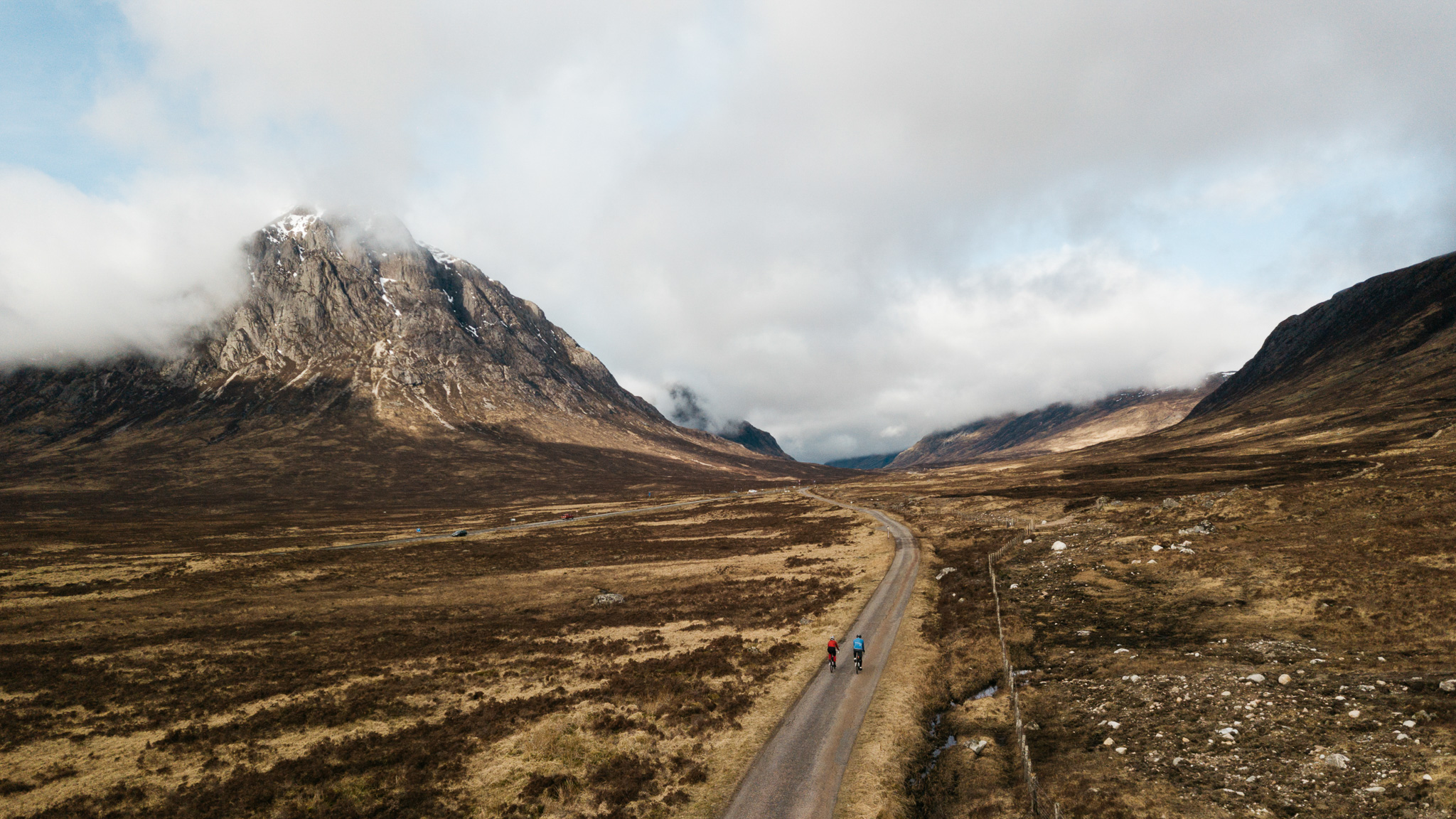A drone shot showing 2 cyclists on the West Highland Way with Buachaille Etive Mor in the background