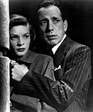 lauren bacall and humphrey bogart hide behind a street corner together in the movie Dark passage