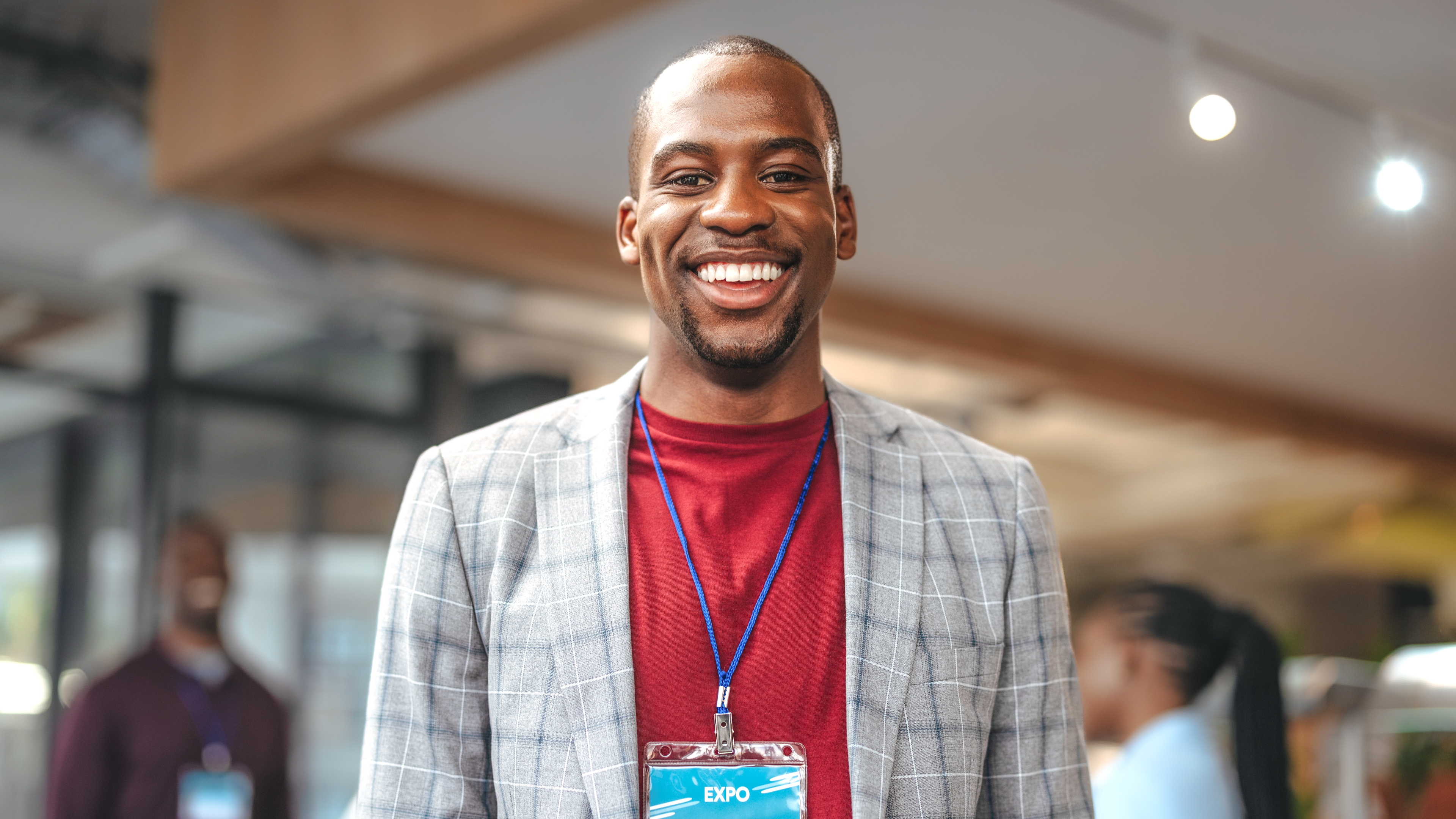 Man smiling wearing an event badge