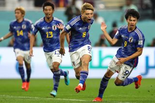 Japan players celebrate a goal against Spain at the 2022 World Cup.