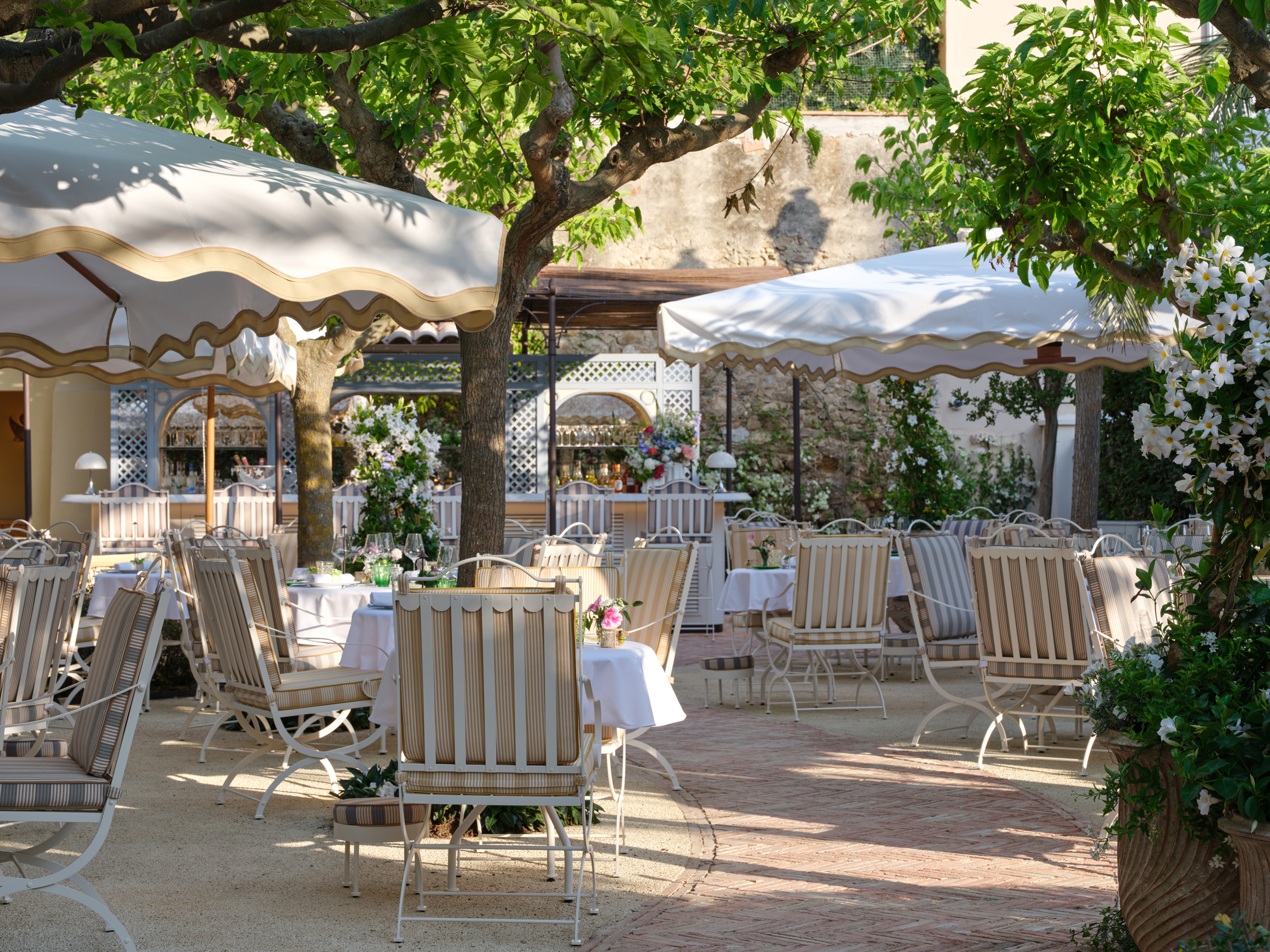 view of the new dior restaurant in saint tropez, an outdoor experience defined by haute couture flavours and lush greenery