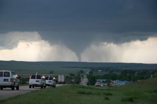 Storm chasing scientists ride toward a tornado in Wyoming, just across the border from Nebraska, during the VORTEX2 mission in 2009.