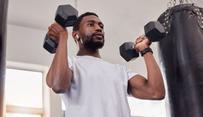 Man exercising with dumbbells at home