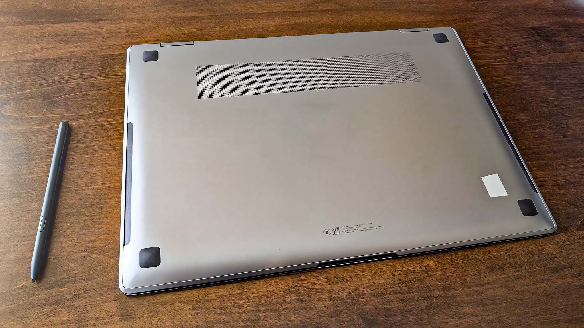 Samsung Galaxy Book5 Pro 360 placed upside down on a table to see bottom vent and rubber footpads.