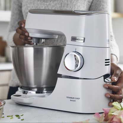 Kenwood Titanium Chef Baker in use on white counter top next to pink roses