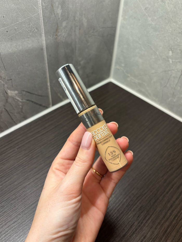Deputy beauty editor Grace Lindsay holding a Loreal concealer