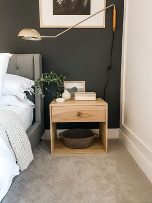 DIY wood nightstand against a dark wall