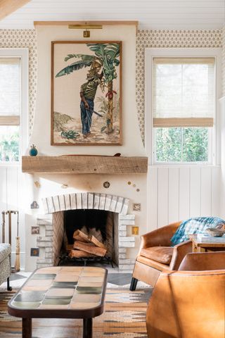 brick and tiled fireplace filled with logs in rustic inspired living room