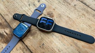 Apple Watch Series 8 and Apple Watch Ultra with Apple Sport Band on wooden table
