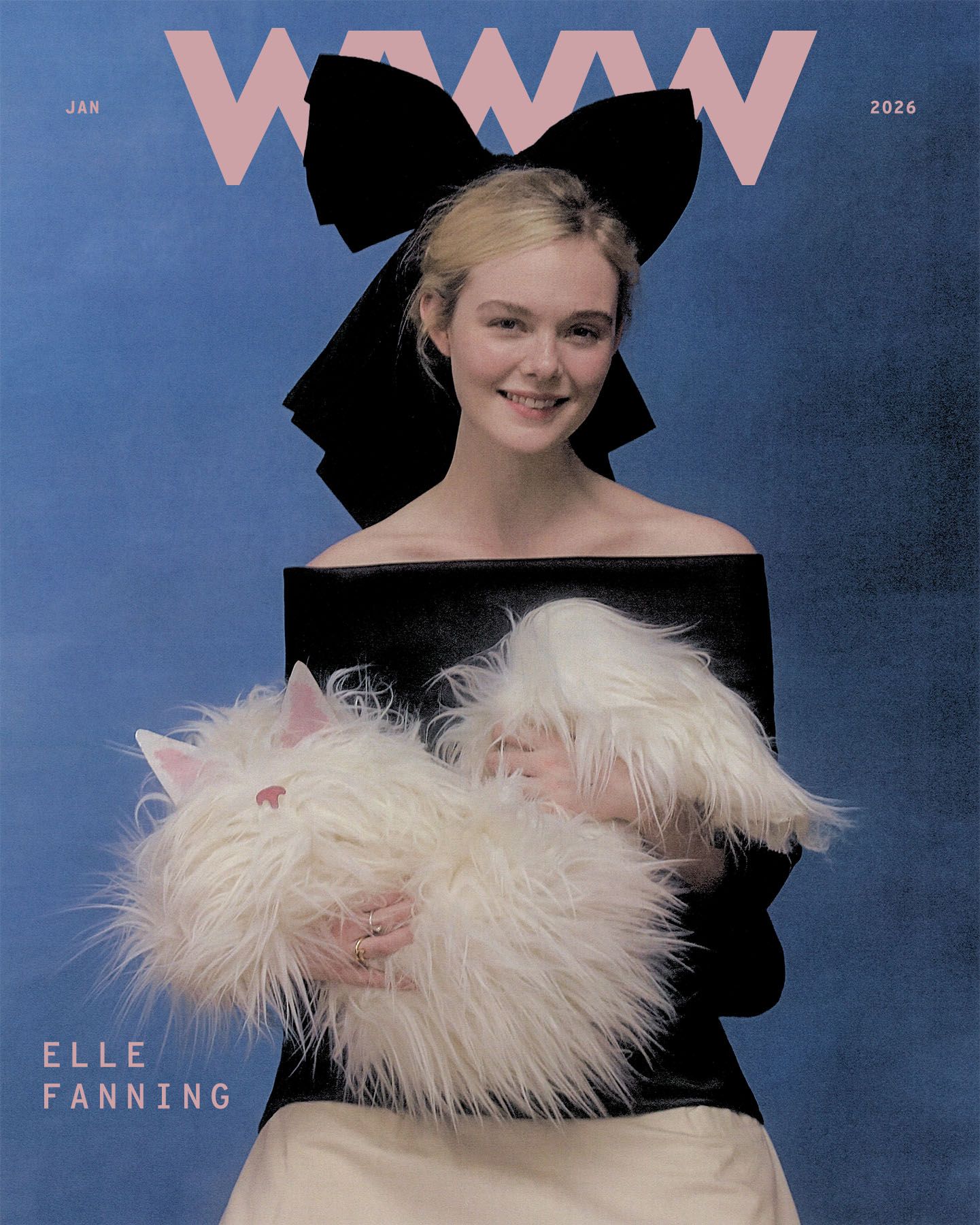 Who What Wear January 2026 cover featuring Elle Fanning shot by Szilveszter Makó. On the cover, Fanning is holding a faux fur scarf shaped to look like a cat. She is wearing an off-the-shoulder black and white dress with an oversize black bow in her hair.