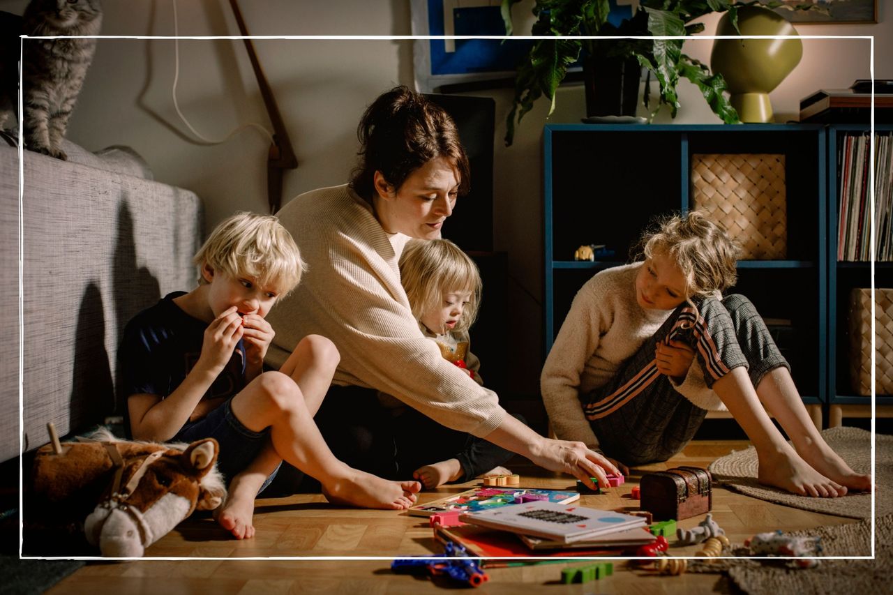 Mother playing with children on floor at home