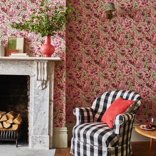 cottagecore decor ideas for living rooms, living room with pink floral ditsy wallpaper, wall light, black and white checked armchair, coral vase on marble mantel,